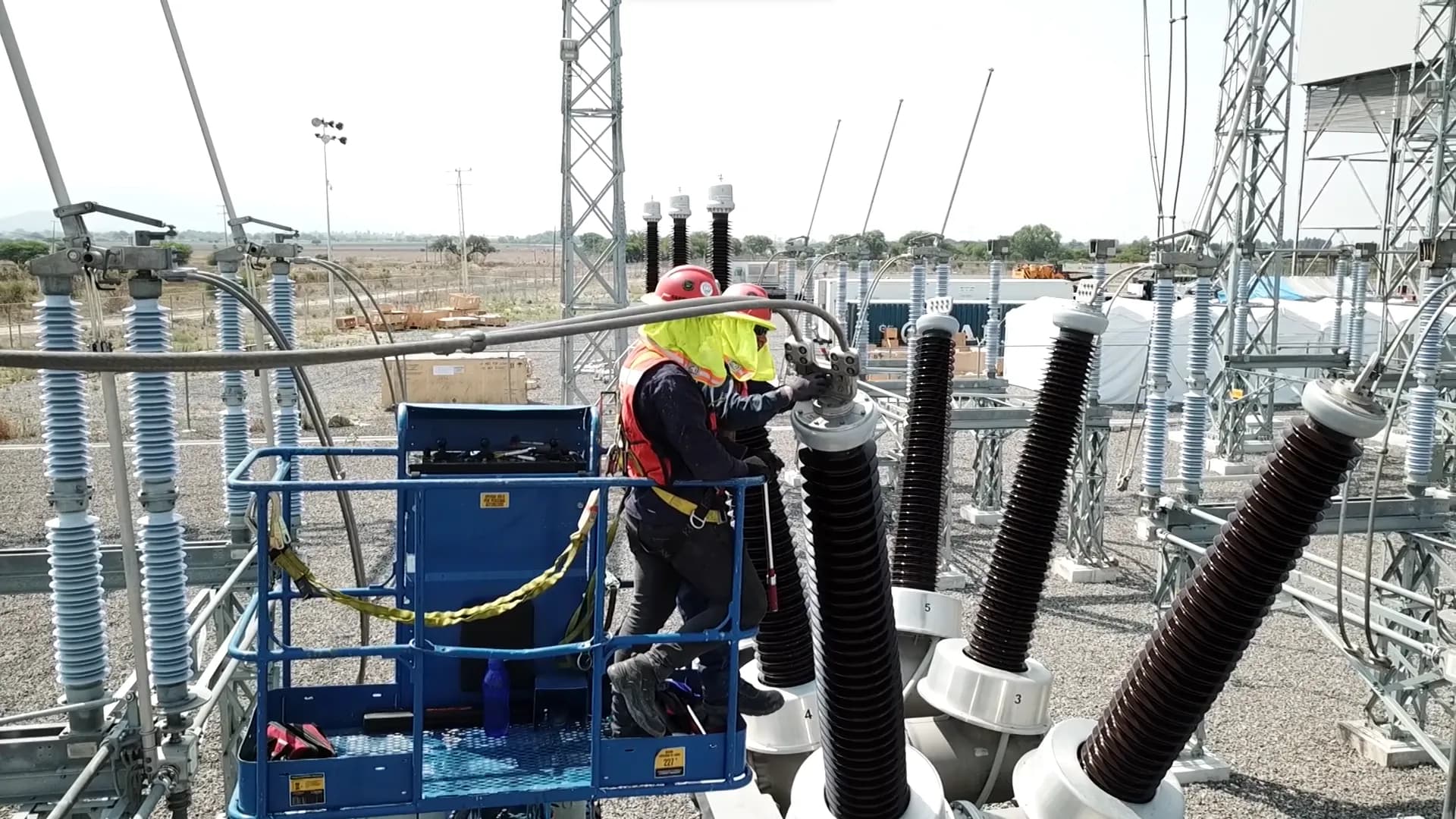Trabajadores instalando a una torre de alta tensión